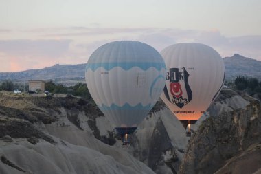 Açık mavi gökyüzünde yüzen iki renkli sıcak hava balonu