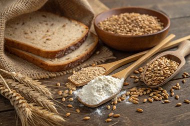 Tahta bir yüzeyde taze ekmek ve tahıl.