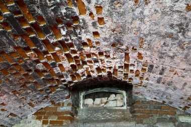 Çürümüş yüzeyi ve mühürlü penceresi olan eski tuğla tavan.