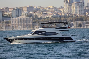 04-10-2024 İstanbul-Türkiye: Arka planda Dolmabahce Sarayı ile birlikte Boğazda lüks bir yat gezisi
