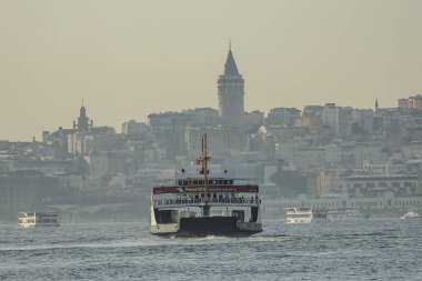 İstanbul 'daki Galata Kulesi siluetiyle Boğaz' da feribot
