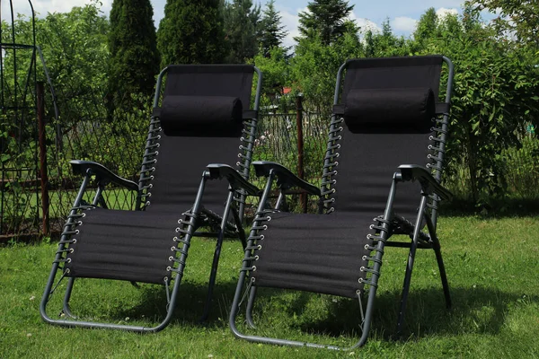 Stock image Reclining sun loungers in the garden on the green gras