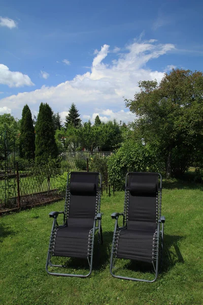 Reclining sun loungers in the garden on the green gras