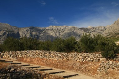 Hırvatistan 'daki dağların tepelerinin manzarası mavi gökyüzü taşlı trai