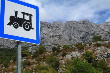 Hırvatistan Makarska 'daki dağların arka planında turizm treni tabelası