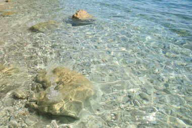 Açık deniz suyu ve taşlar.
