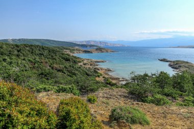 İnsansız çakıl taşı plajı Croati 'de dinlenecek bir ada Rab' bi.