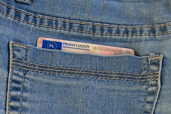 Driver\'s license document in the back pocket of blue  jean