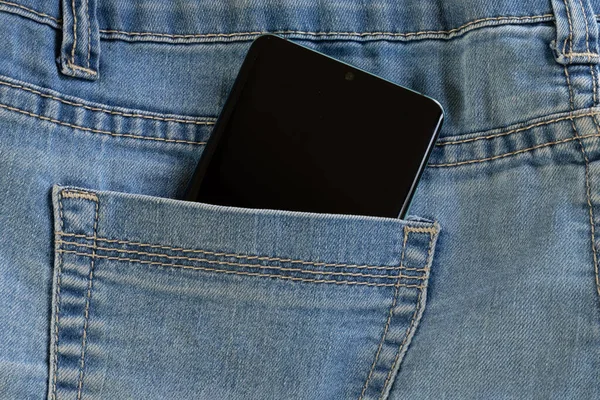The phone is carried in the back pocket of blue jean
