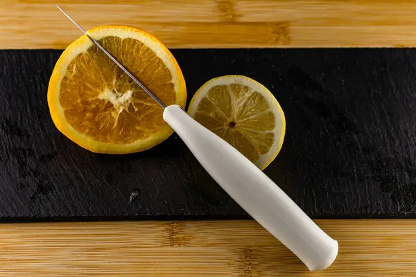 Yellow lemon cut in half on a stone slab, citrus fruits