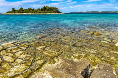 Hırvatistan 'da romantik plaj, gök mavisi su, Rovinj Istri' nin kayalık kıyıları
