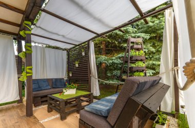 Bahçe terası, dinlenme yeri, ahşap paletler, pergola ve çiçeklerden yapılmış bahçe mobilyaları.