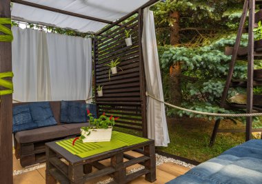 Bahçe terası, dinlenme yeri, ahşap paletler, pergola ve çiçeklerden yapılmış bahçe mobilyaları.