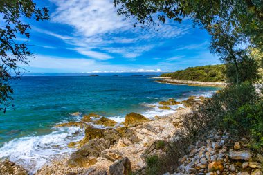 Hırvatistan 'ın İstrian kıyısındaki Rovinj yakınlarındaki turistler için erişilemez boş kayalık plajlar