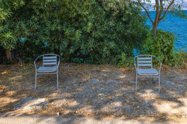 Trpanj, Croatia, Guarded parking lot by the beach, no parking allowed, two chairs under a tre clipart