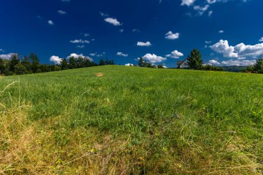 Silesian Beskids 'da bir çayırda çimleri biçmek, dağ manzarası