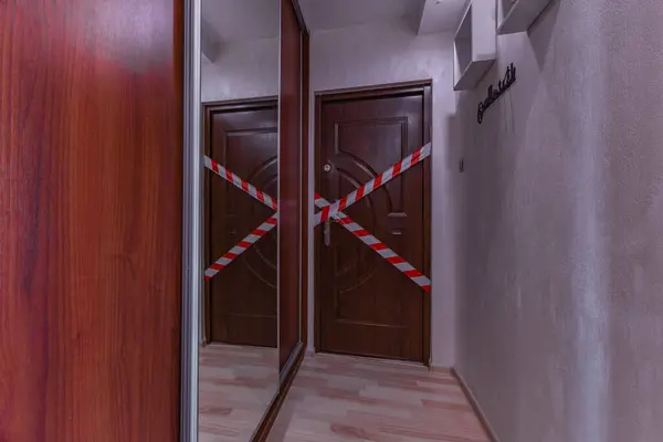 Stock image The entrance door to the apartment, police tape, secured the crime scene, burglary into the apartment