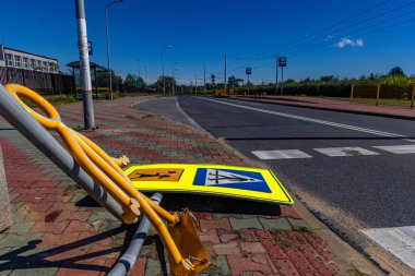 Road accident on the lanes next to a marked pedestrian crossing to school, damaged road sign, reflective figure warning about the pedestrian crossing torn off clipart