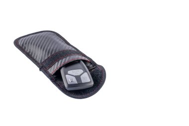 Araba anahtarlarını beyaz arka planda, koruyucu bir çantada, araba hırsızlığına karşı arabayı koruyor.