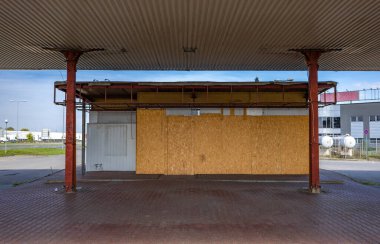 Pasif ve terk edilmiş benzin istasyonu, pasif konteynerler, kapalı pencereler, çitli alan, şehir merkezindeki eski istasyon.