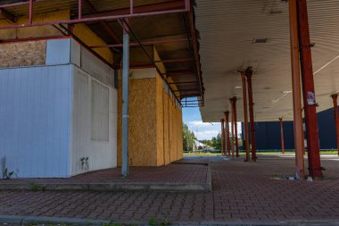 Pasif ve terk edilmiş benzin istasyonu, pasif konteynerler, kapalı pencereler, çitli alan, şehir merkezindeki eski istasyon.