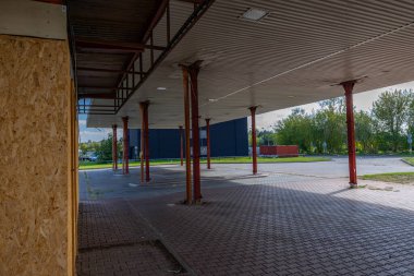 Pasif ve terk edilmiş benzin istasyonu, pasif konteynerler, kapalı pencereler, çitli alan, şehir merkezindeki eski istasyon.
