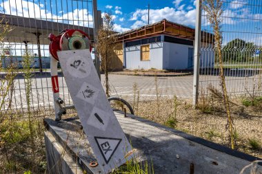 Pasif ve terk edilmiş benzin istasyonu, pasif konteynerler, kapalı pencereler, çitli alan, şehir merkezindeki eski istasyon.