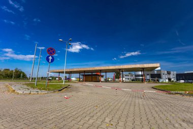 Pasif ve terk edilmiş benzin istasyonu, pasif konteynerler, kapalı pencereler, çitli alan, şehir merkezindeki eski istasyon.