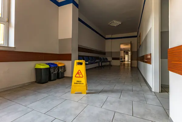 Dikkat: Kaygan, ıslak zemin, okulda, klinikte, hastanede, tehlike hakkında sarı uyarı işareti
