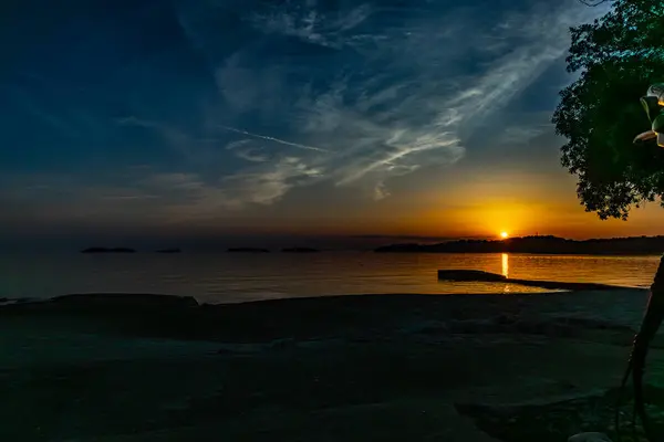 Dağların arkasındaki batan güneş, Rovinj Hırvatistan yakınlarındaki Akdeniz kıyılarının manzarası