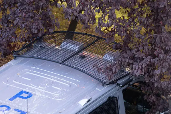 Polis baskını sırasında yolda park etmiş büyük bir polis arabası, suçluları taşımak için bir minibüs.