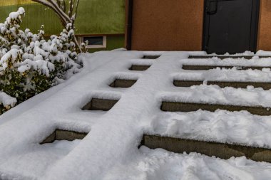 İlk kar yağışı, karla kaplı merdivenler ve eve giden tekerlekli sandalye rampası, kaygan merdivenlere dikkat et.