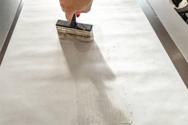 Duvar kağıdına kalın yapıştırıcı sürüyorum, duvara yapıştırmadan önce duvar kağıdını fırçalıyorum, vinile güçlü bir yapıştırıcı sürüyorum, duvar kağıdı yapıştırıyorum.