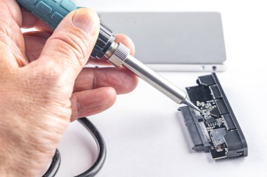 Hasarlı harici sürücü, beyaz arka planda transformatör lehimleme demiri, hizmet merkezinde elektronik ekipman onarımı