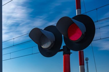 Demiryolu kavşağındaki trafik ışıkları, rayların önündeki kırmızı ışık, raylara giriş yok, tren güneşli.