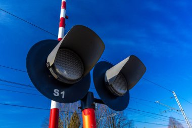 Demiryolu kavşağındaki trafik ışıkları, rayların önündeki kırmızı ışık, raylara giriş yok, tren güneşli.