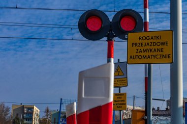Demiryolu kavşağındaki trafik ışıkları, rayların önündeki kırmızı ışık, raylara giriş yok, tren güneşli.
