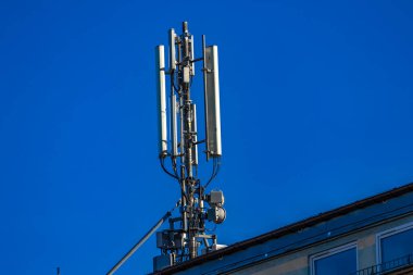 Bir binanın çatısındaki anten, karasal televizyon alımı, şifreli mesajlar, zararlı radyasyon, 5G sinyali.