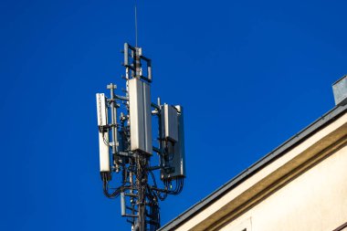 Bir binanın çatısındaki anten, karasal televizyon alımı, şifreli mesajlar, zararlı radyasyon, 5G sinyali.