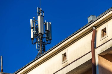 Bir binanın çatısındaki anten, karasal televizyon alımı, şifreli mesajlar, zararlı radyasyon, 5G sinyali.