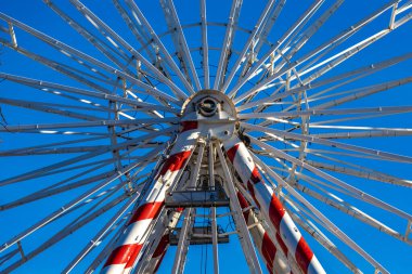 Şehir merkezindeki eğlence parkı, büyük dönme dolap, uzun atlıkarınca turistik cazibesi, gökyüzüne karşı beyaz atlı karınca arabaları.