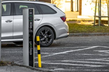 Şehir merkezindeki bir otoparktaki elektrikli araba şarj istasyonu, elektrikli araba şarjı olan boş bir park yeri, servis dışı elektrikli araç şarj istasyonu.