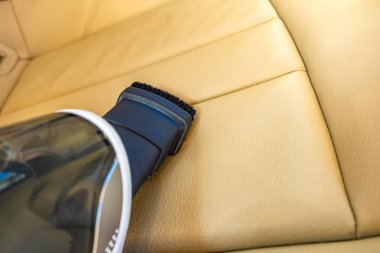 El bilgisayarı pille çalışan elektrikli süpürge, arabanın içindeki çöpleri temizlemek, bej araba koltuğunu yenilemek...