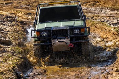 Yeşil off-road arabası, derin çamura gömülü araç, off-road yarışması