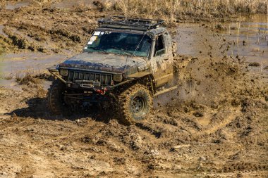 Aşırı yol koşulları, off-road araçları için zor yol, off-road otomobil rac pistinde su, çamur ve kumla büyük bir engeli aşma girişimi