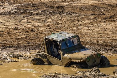 Hasarlı off-road aracı, su basmış motor, su ve çamurla dolu bir hendeğe sıkışmış araç, arabayı yüzmeden çıkarmaya teşebbüs.
