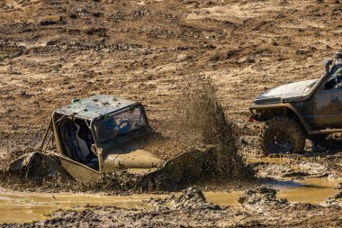 Hasarlı off-road aracı, su basmış motor, su ve çamurla dolu bir hendeğe sıkışmış araç, arabayı yüzmeden çıkarmaya teşebbüs.