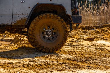 Çamur ve kumla kaplı arazi aracı lastikleri, su ve çamurla geçen araba, off-road aracı Towin.