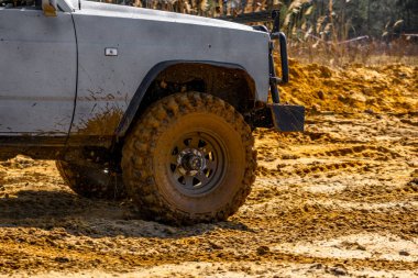 Çamur ve kumla kaplı arazi aracı lastikleri, su ve çamurla geçen araba, off-road aracı Towin.