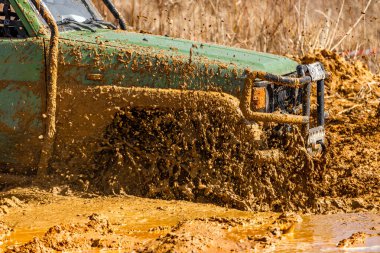 Çamur ve kumla kaplı arazi aracı lastikleri, su ve çamurla geçen araba, off-road aracı Towin.